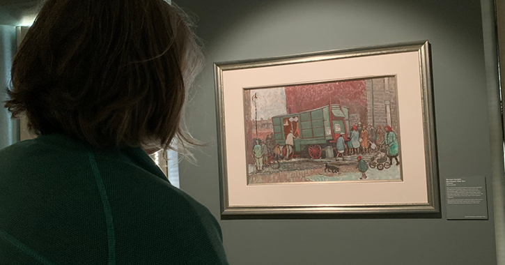 Woman stood in front admiring a painting by Norman Cornish inside The Mining Art Gallery